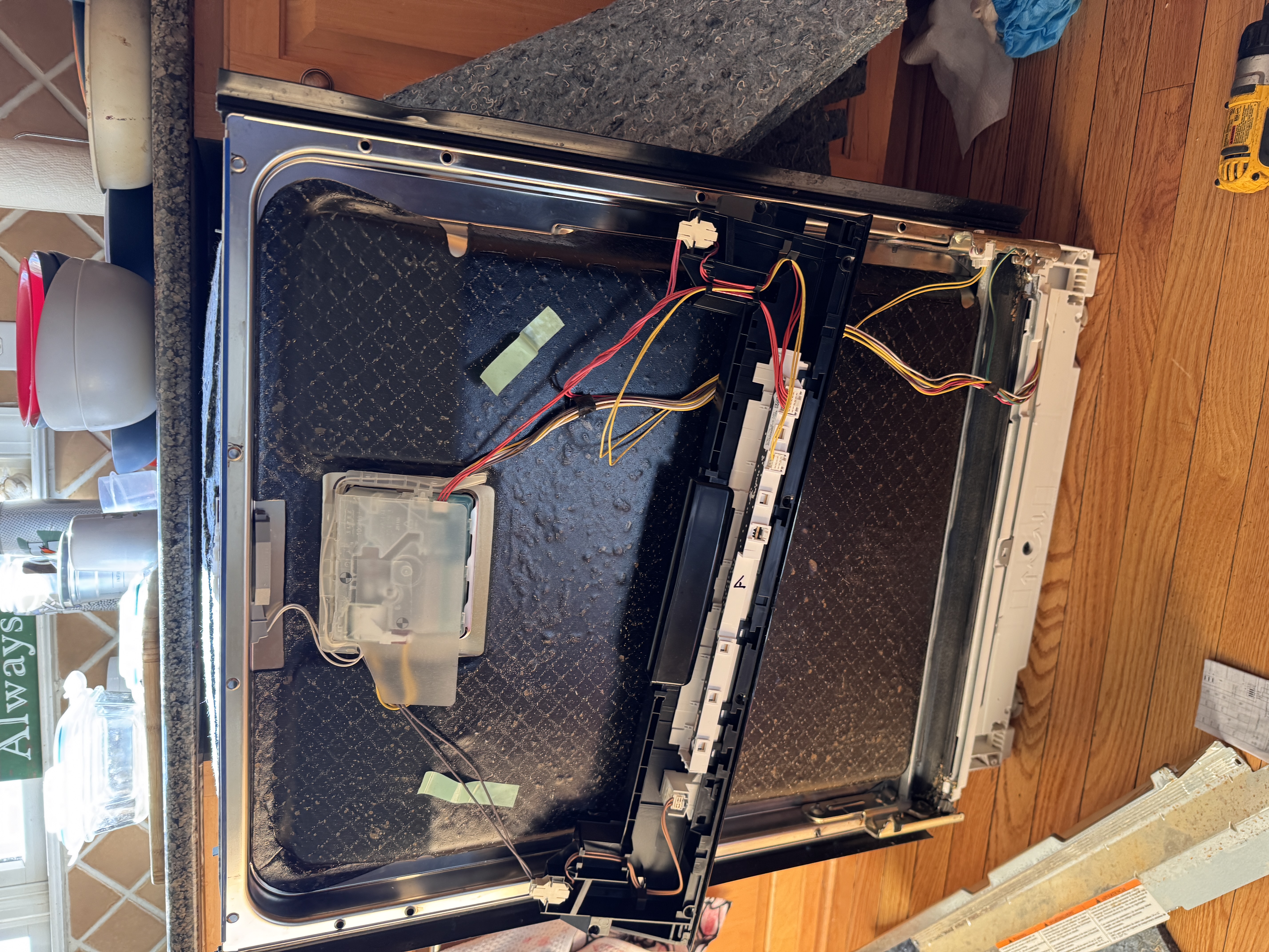 Dishwasher door fully disassembled — control board and wiring repair
